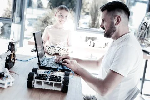 Serious teacher programming robot of his student Foto stock