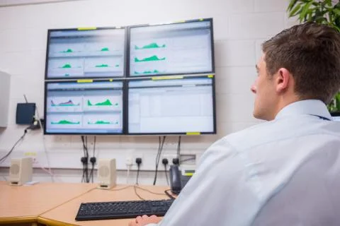 Serious technician looking at computer screen 写真素材