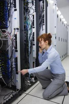 Serious technician talking on phone while analysing server Stock Photos