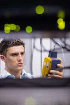 Serious technician using digital cable analyzer on server Stock Photos