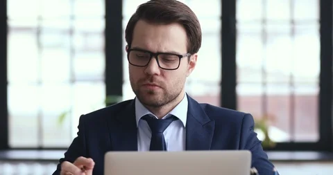 Serious thoughtful businessman solving problems working on laptop making notes Stock Footage 126252288