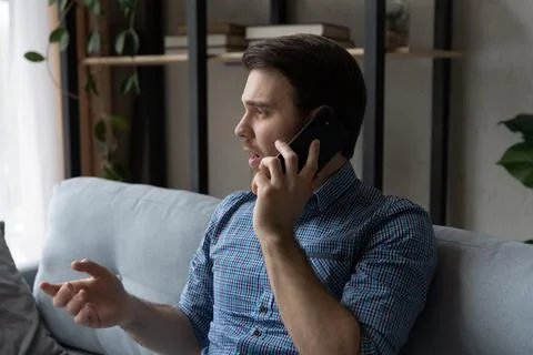 Serious thoughtful mobile phone user making telephone call from home Stock Photos