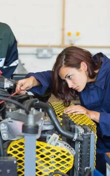Serious trainee checking a machine Stock Photos