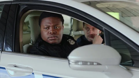 Serious two men cops sitting in patrol car take photo accepting emergence call Stock Footage 112954279