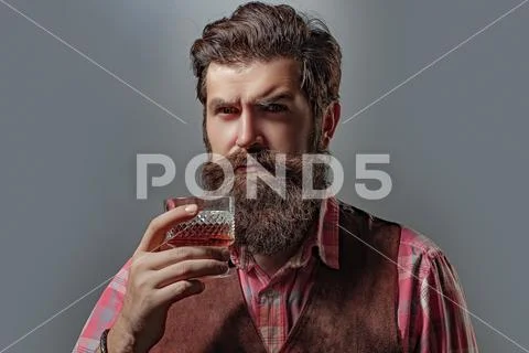Serious unhappy sad man pouring vodka while having alcohol addiction. Confident Stock Photos