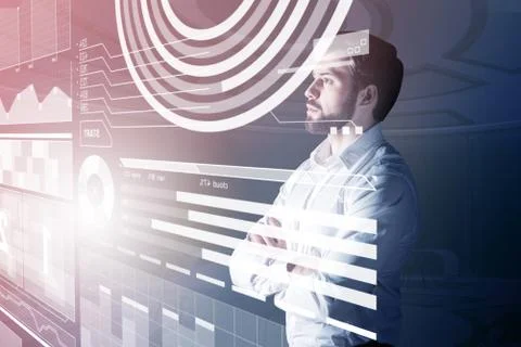 Serious web developer standing with arms crossed and looking at the screen Foto stock