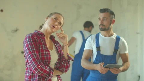 Serious woman talks about flat with builder Stock Footage 124847237