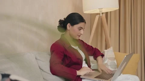 Serious woman using laptop checking email news online sitting on sofa Stock Footage 240284135
