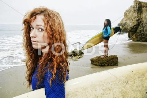 Serious women holding surfboards at beach Stock Photos