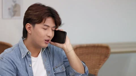 Serious Young Asian Man Talking on Smartphone in Denim Shirt Stock Footage 332895972