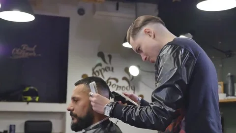Serious Young Bearded Man Getting Haircut By Barber. Barbershop Theme. Slow Stock Footage 69099203