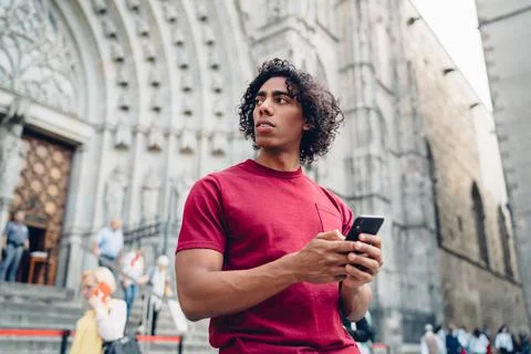 Serious young black man using cellphone and looking away during vacation Stock Photos