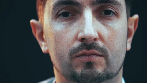 Serious young concentrated man looking at the camera, then closing his eyes. Stock Footage 130267544