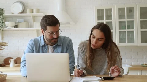 Serious young couple paying bills online on website app Stock Footage