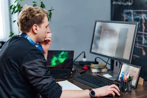 Serious young man concentrated on problem on the PC screen. Smart programmer  Stock Photos