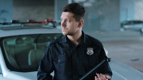 Serious young man cops stand near patrol car look at camera enforcement Stock Footage 113005536
