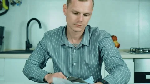 Serious young man customer opening parcel package with black lady bug sitting at Stock Footage 228436237