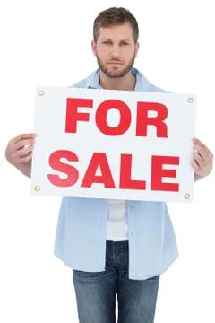 Serious young man holding a for sale sign Stock Photos