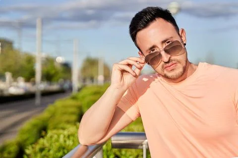Serious young man looking at the camera over sunglasses on a sunny day. Foto stock