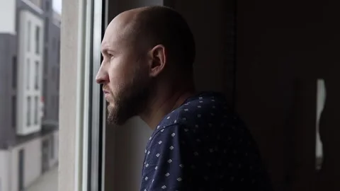 Serious young man looking out the window Stock Footage 242719898