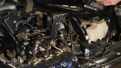 Serious young man repairing his motorcycle in garage Stock Footage