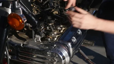Serious young man repairing his motorcycle in garage Stock Footage