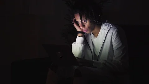 Serious young man sitting on couch and using laptop at night Stock Footage 101430203
