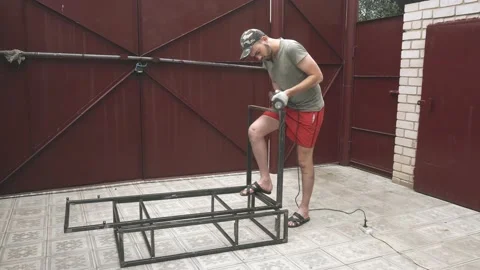 Serious young man in work uniform and gloves with a drill in his hands Vidéo 145395662
