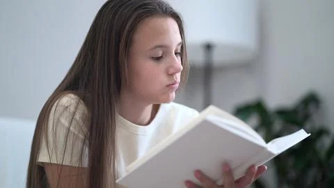 Serious young student absorbs knowledge from a book in a calm indoor settin.. Stock Photos