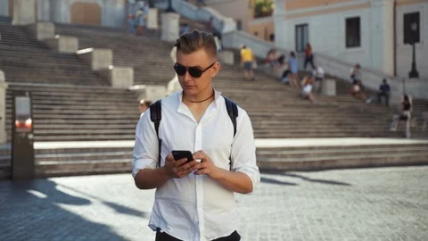 Serious young tourist checking mobile application on his modern technology Video stock 113547289