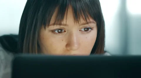 Serious young woman using computer at night. She found what she was looking for Stock Footage 60766680