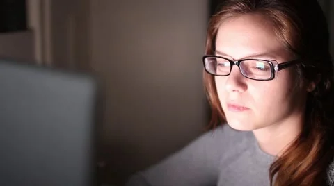 Serious young woman using computer at night Stock Footage 64287519