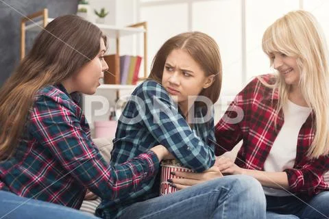 Serious young women do not sharing popcorn with friend Stock Photos