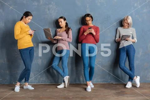 Serious young women leaning to the wall Stock Photos