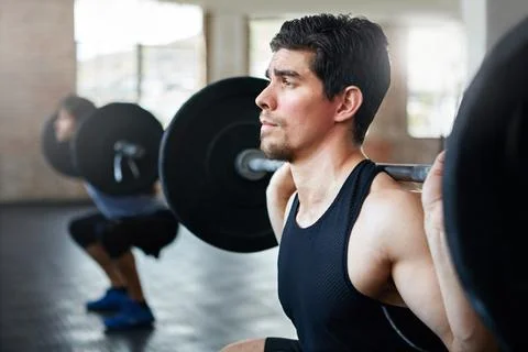 Seriously strong. young men working out with weights in the gym. Stock Photos