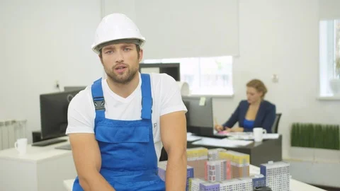 Seroious builder tells something at the camera and frowns Stock Footage 121803408