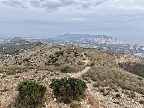 Serpentine Pathway Ascending From Rough Hillside To Vibrant Metropolitan Stock Photos