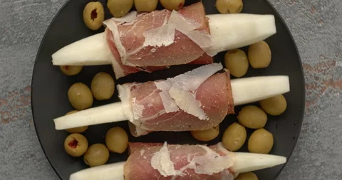 Serrano ham and melon with olives and hard cheese flakes snack. Stock-Footage 279923217