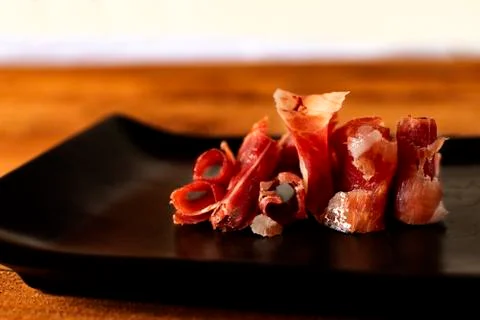 Serrano ham chips on a plate. Stock Photos