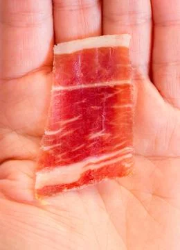 Serrano ham slice and hand Stock Photos