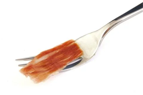 Serrano ham slice on metal fork. Jabugo. Spanish tapa Stock Photos