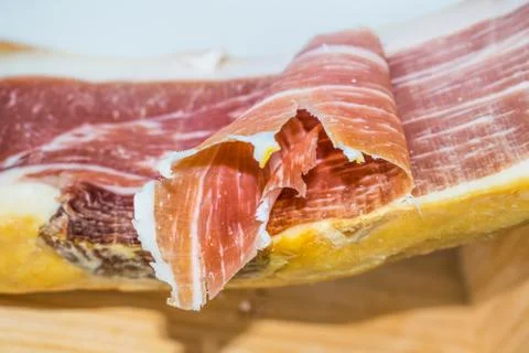 Serrano ham on wooden surface Stock Photos