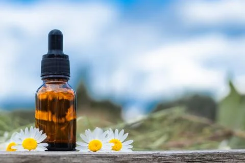 Serum with chamomile extract on the background of the sky, concept natural co Stock Photos