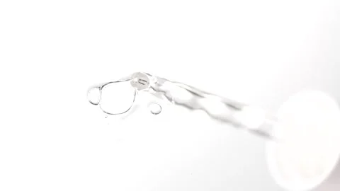 Serum in pipette drips on a white surface. Dropper for cosmetic fluid with .. Stock Footage 305073111