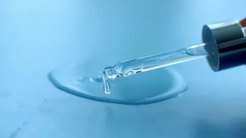 Serum pipette with a falling drop on a blue background Stock Footage 196533698