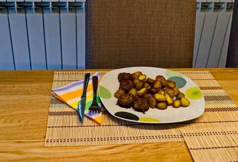 Served appetizing dinner of fried potatoes and green salad on a table Stock Photos