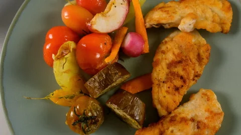 Served baked cooked vegetables with chicken meat slices on plate, close-up view. Video stock 312464450