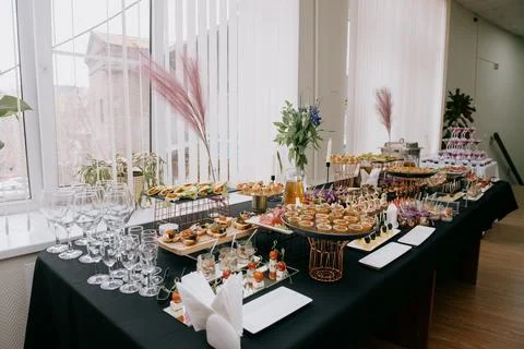A served buffet table with a variety of cold appetizers and glasses Stock Photos