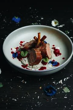 Served duck with floral garnish on rustic table Stock Photos