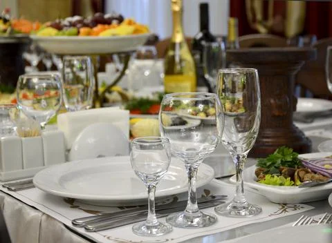 Served festive table with empty glasses and plates Stock Photos